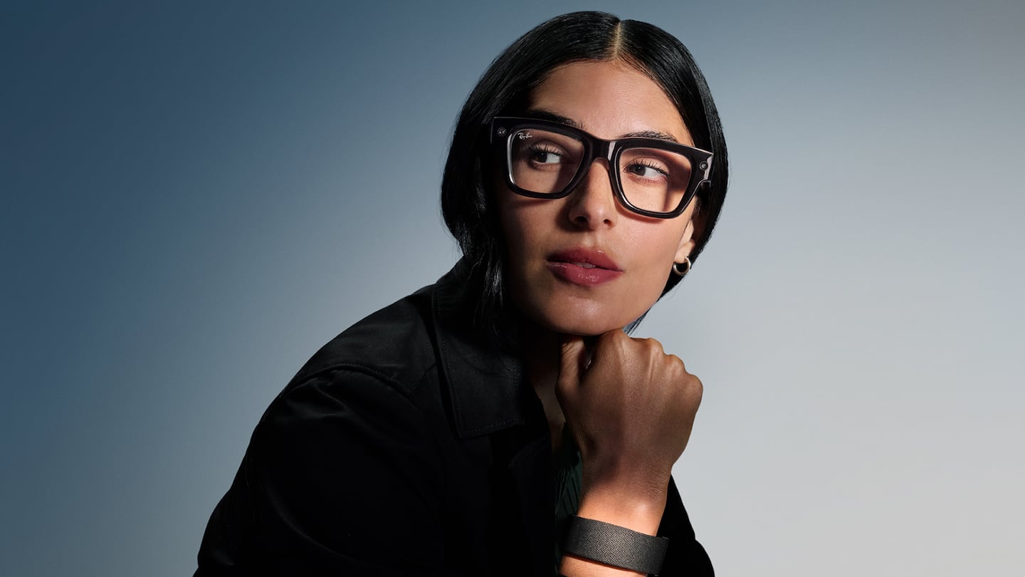 A model wears the Meta Ray-Ban Display glasses and the Neural Band.